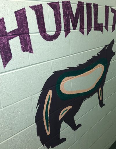 A mural depicting a wolf and the word "humility"
